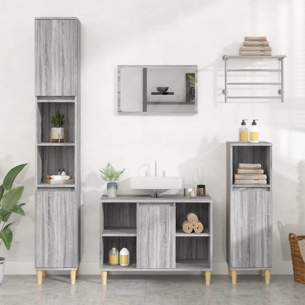 Grey Sonoma sink cabinet made of engineered wood, featuring a central sink, storage compartments, and tall shelving units, complemented by light wooden legs and decorative plants.