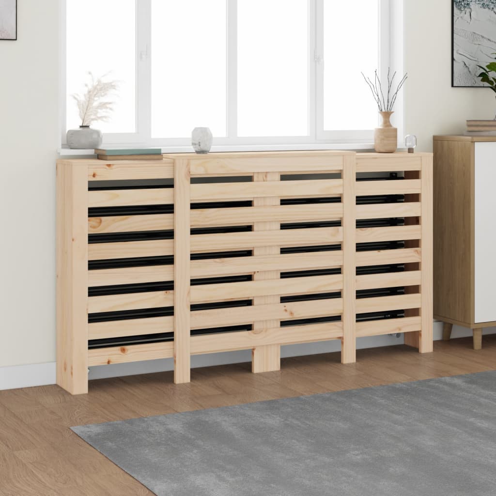 Solid wood radiator cover in brown pine, measuring 210x21x85 cm, featuring a slatted design with a smooth finish, positioned against a light wall near a window.