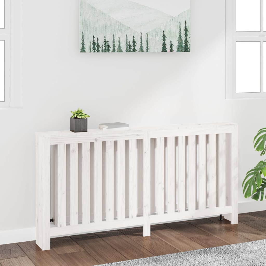 White radiator cover made of solid pine wood, measuring 169x19x84 cm, featuring slatted design, placed against a light wall with a small plant and a book on top.