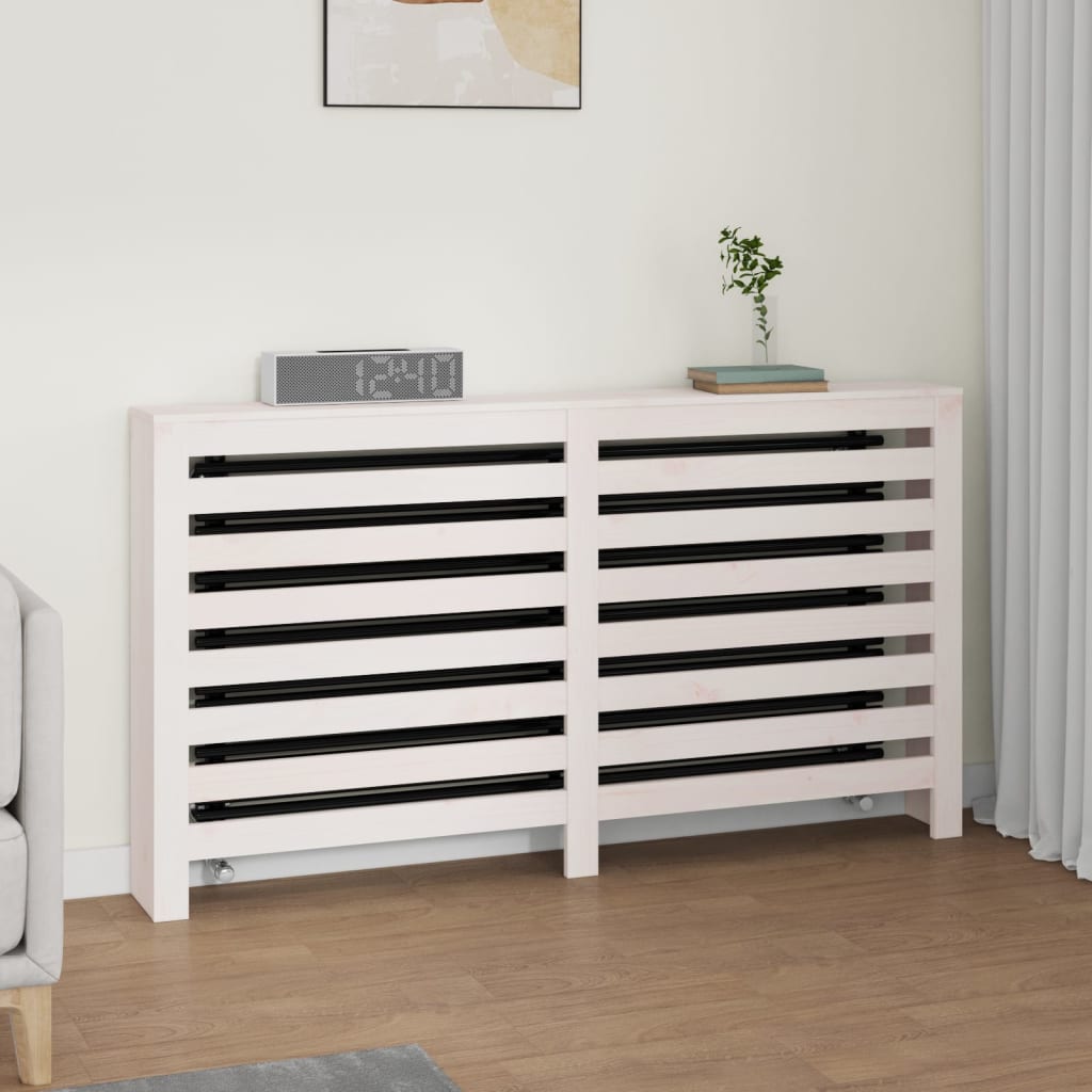 White radiator cover made of solid pine wood, measuring 153x19x84 cm, featuring slatted design and a smooth finish, placed against a light-colored wall with decor items on top.