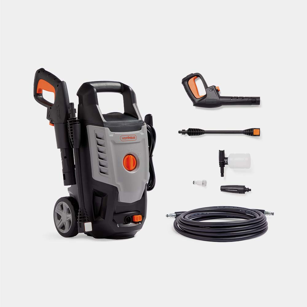 Grey VonHaus 1600W pressure washer with a prominent orange button, two wheels for mobility, a detachable spray gun, various nozzles, and a hose for versatile cleaning tasks.