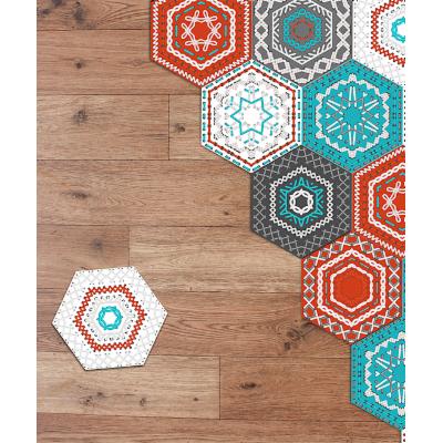 Colorful hexagon floor tile stickers in red, turquoise, and gray with intricate patterns, arranged on a wood-like surface, showcasing DIY art and home decoration potential.