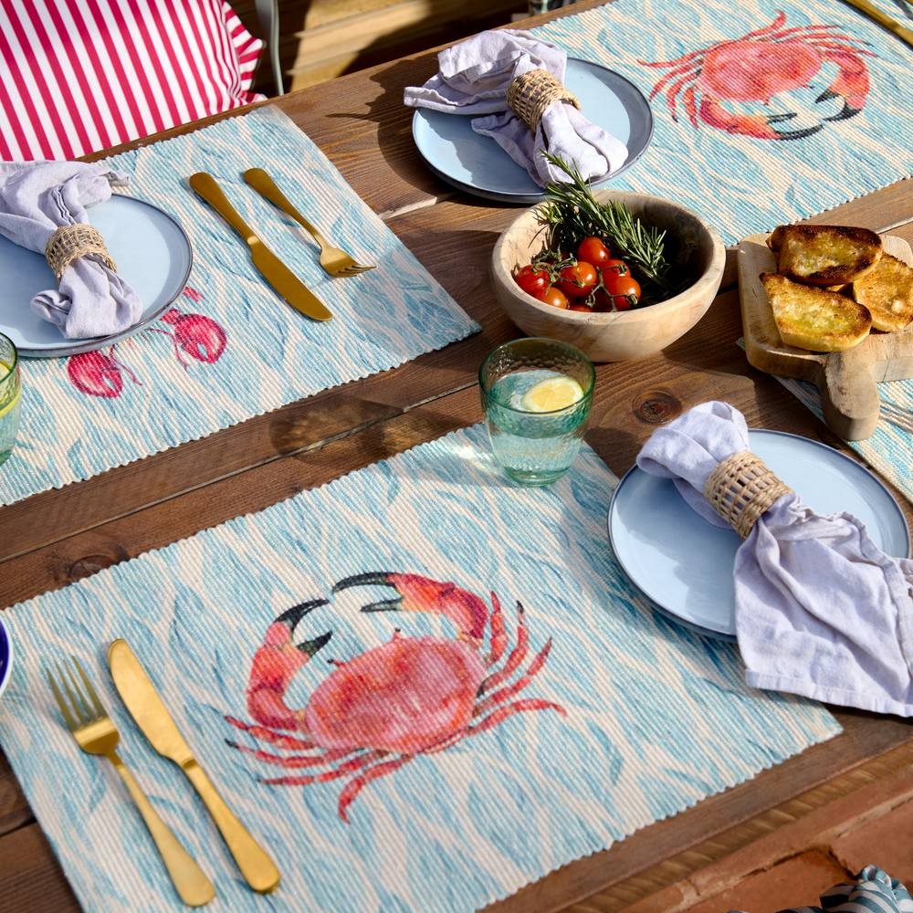 Set of 4 blue indoor/outdoor placemats featuring a playful crab design, made from durable material, perfect for casual dining and outdoor use.