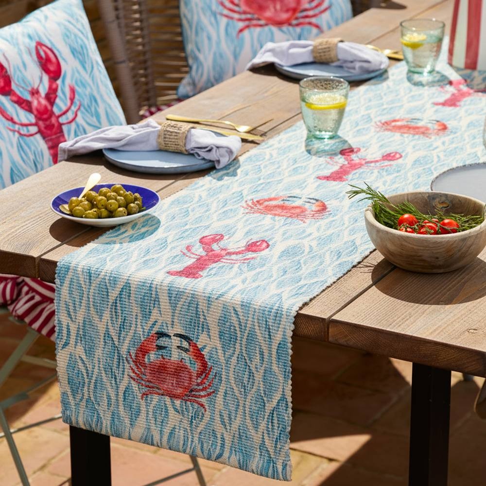 Colorful indoor/outdoor table runner featuring a blue wave pattern with red lobsters and crabs, measuring 220 x 35 cm, perfect for adding a nautical touch to dining settings.