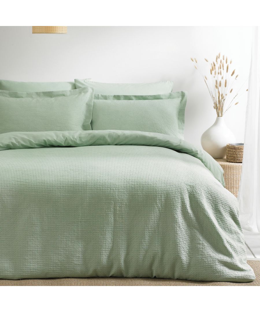 Super King duvet set in seafoam green, made from soft cotton with a textured waffle design, includes matching pillowcases, styled with a minimalist decor backdrop.