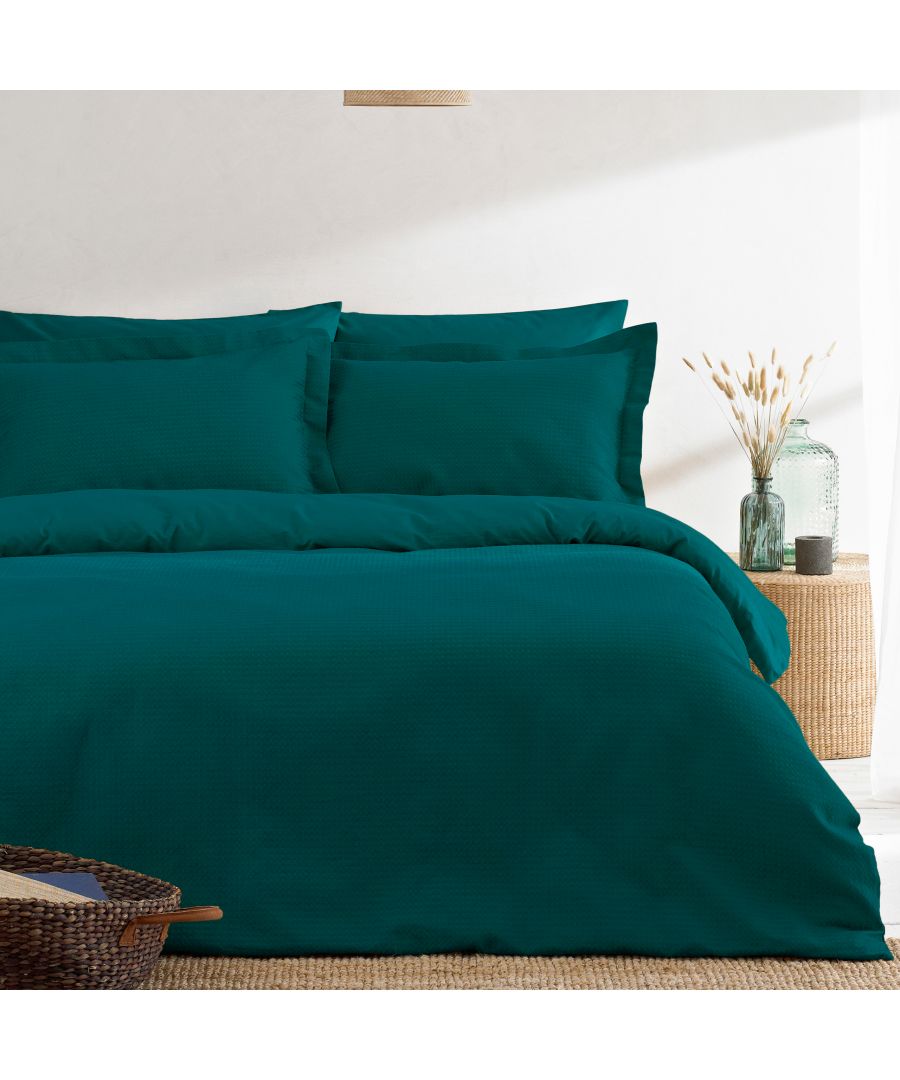 Teal waffle-textured super king duvet cover set made of cotton, featuring matching pillowcases, styled with natural decor elements in a bright setting.