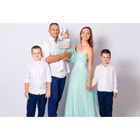 Family photoshoot session with parents and three children in coordinated outfits, white backdrop, by Studio Rooms.