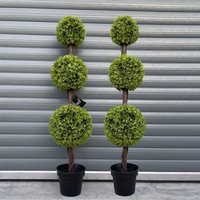 Pair of 120cm green triple ball topiary trees in black pots with realistic foliage against a corrugated metal background.