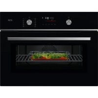 Black AEG CombiQuick oven-microwave with digital display, two knobs, and a glass door showing food inside.