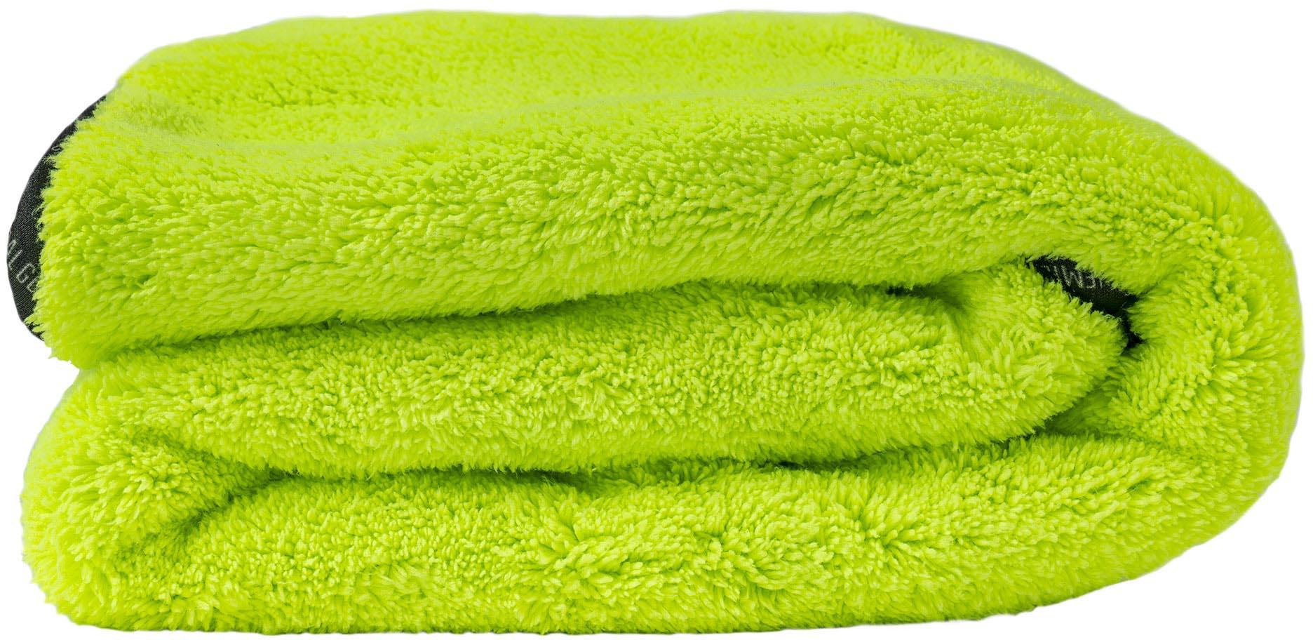 Bright green plush drying towel, thick and fluffy texture, folded neatly.