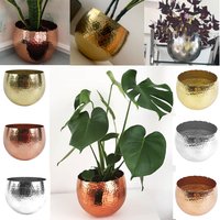 Curved planters in gold, copper, and silver finishes, textured surface, various designs, with plants inside.