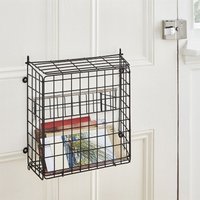 Black wire letter box catcher cage with lift-up lid, mounted on a white door, holding colorful mail.