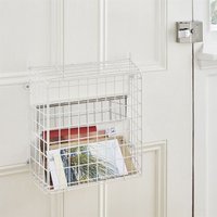White wire letter box catcher basket with lift-up lid, mounted on a door, holding various mail items.