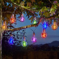 Set of 10 colorful neon-esque solar lightbulbs hanging on a tree branch, glowing in various vibrant colors.