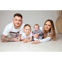 Family photoshoot voucher with three prints, featuring a smiling family of four lying on a white floor.