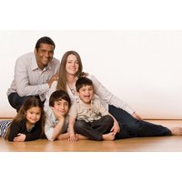 Family photoshoot package with framed photograph, featuring a smiling family of five on a wooden floor.