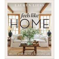 "Feels Like Home book by Lauren Liess with cozy living room cover, white sofa, wooden beams, and large windows"