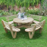 Circular wooden picnic table with seat backs, natural finish, set on grass, surrounded by greenery.