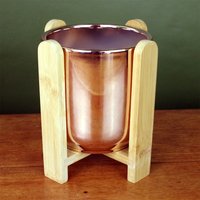 Gold ceramic planter with bamboo stand, featuring a glossy finish and cylindrical shape, ideal for indoor plants.