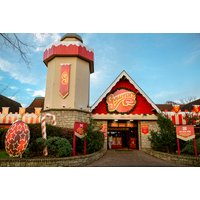 Gulliver's Valley festive park entrance with red-roofed tower, candy cane decor, and holiday banners.