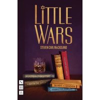 "Little Wars book with gold title, purple cover, and stacked books including a glass of whiskey on a wooden table"