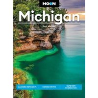 "Moon Michigan travel guidebook with scenic lake and rocky shoreline on cover, featuring lush greenery and clear blue water"