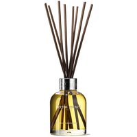 Molton Brown citrus diffuser with amber liquid, silver cap, and dark reeds in a clear round bottle.