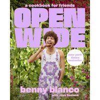 Cookbook "Open Wide" with purple text, featuring a person in floral overalls eating outdoors, surrounded by greenery.