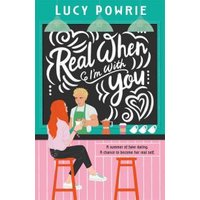 Book cover "Real When I'm With You" by Lucy Powrie, features a couple at a cafe counter with a chalkboard backdrop.