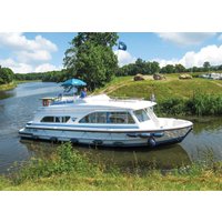 White "Tango" canal boat by Hoseasons with blue trim, upper deck seating, cruising on a lush green riverbank.