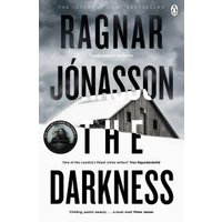 Paperback book "The Darkness" by Ragnar Jónasson, featuring a snow-covered house under a cloudy sky on the cover.
