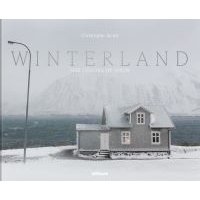 "Winterland book cover featuring a snowy landscape with a gray house and mountains in the background"