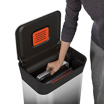 Stainless steel 30 L Titan trash bin with a sleek black lid, featuring a red vent panel, and a user placing a trash bag inside.