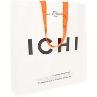 White paper tote bag by Ichi with bold black text and orange handles.