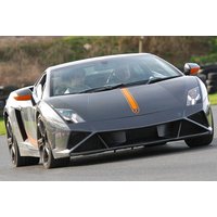 Black Lamborghini Gallardo with orange stripe on track, sleek design, low profile, sharp headlights.