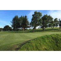 Lochgelly Golf Club scenic parkland course with lush green fairways, surrounded by trees under a clear blue sky.