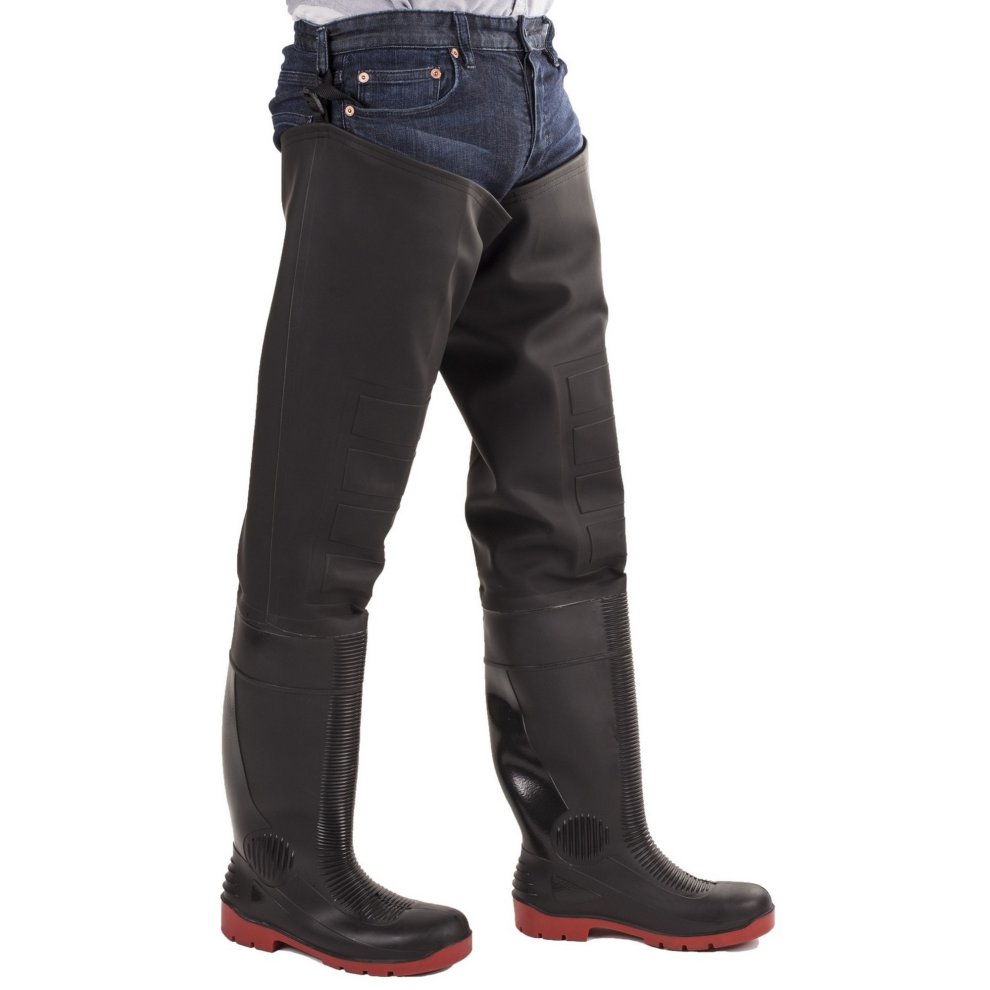 Black rubber thigh waders with a textured finish, reinforced seams, and red rubber soles, worn over blue jeans, designed for safety and durability in wet environments.