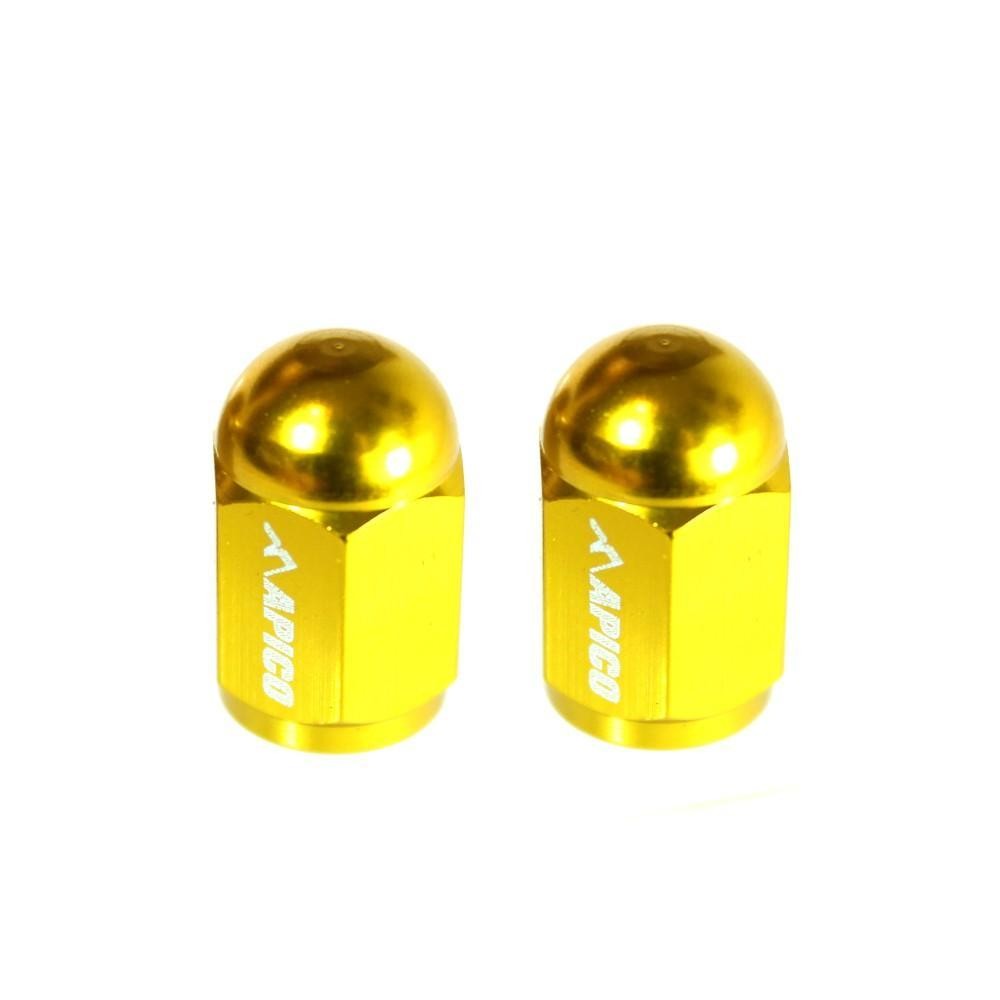 Two yellow CNC-machined aluminum valve caps with a rounded top and hexagonal base, featuring the "Apico" logo engraved on the side.