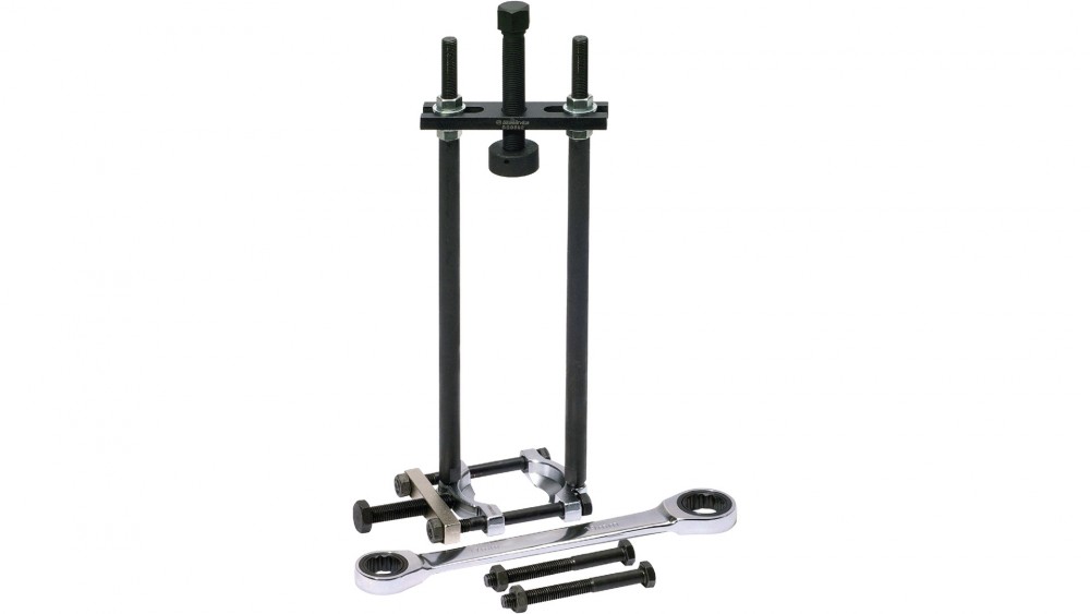 BikeService Steering Tube Bearing Puller Kit featuring a black metal frame, chrome steel rods, and various bolts and wrenches for efficient bearing removal.