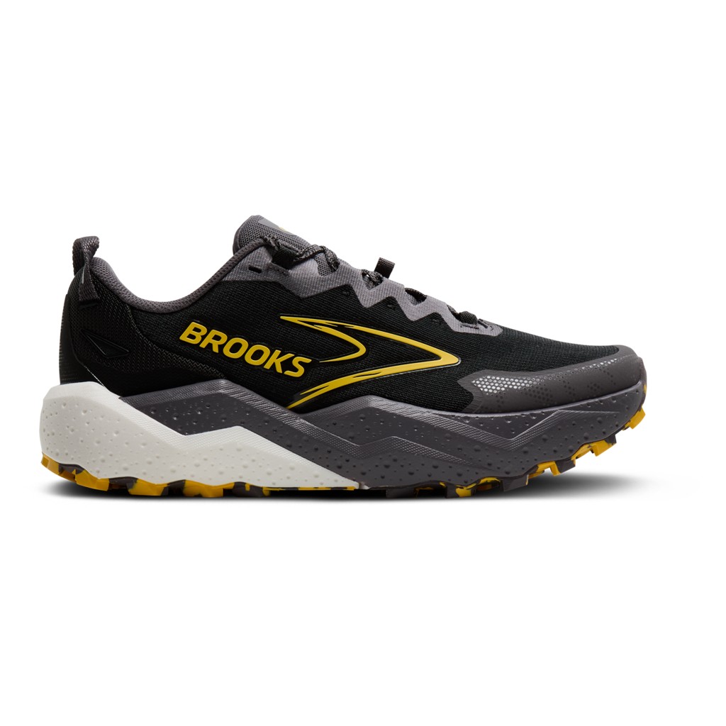Black and gray trail running shoe with yellow accents, featuring a textured sole for traction, a cushioned midsole, and the "Brooks" logo prominently displayed on the side.