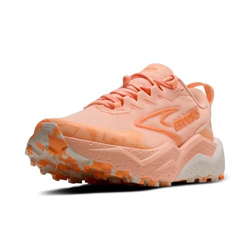 Light peach trainers with a textured upper, featuring a prominent Brooks logo, rugged sole for traction, and a cushioned design, ideal for running or trail activities.