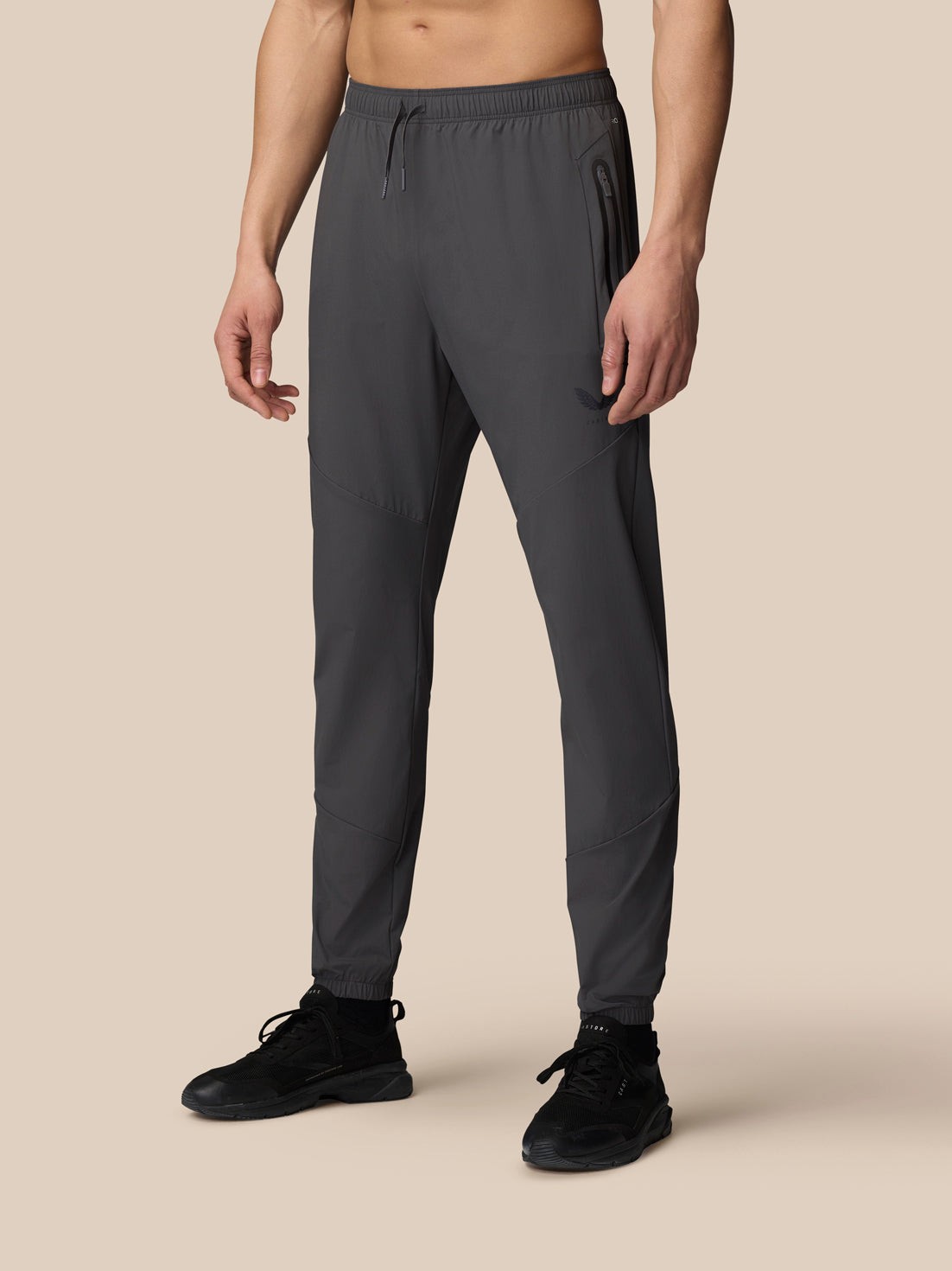 Men's grey lightweight joggers by Castore, featuring an elastic waistband, zippered pockets, and tapered legs, made from breathable material for comfort and style.