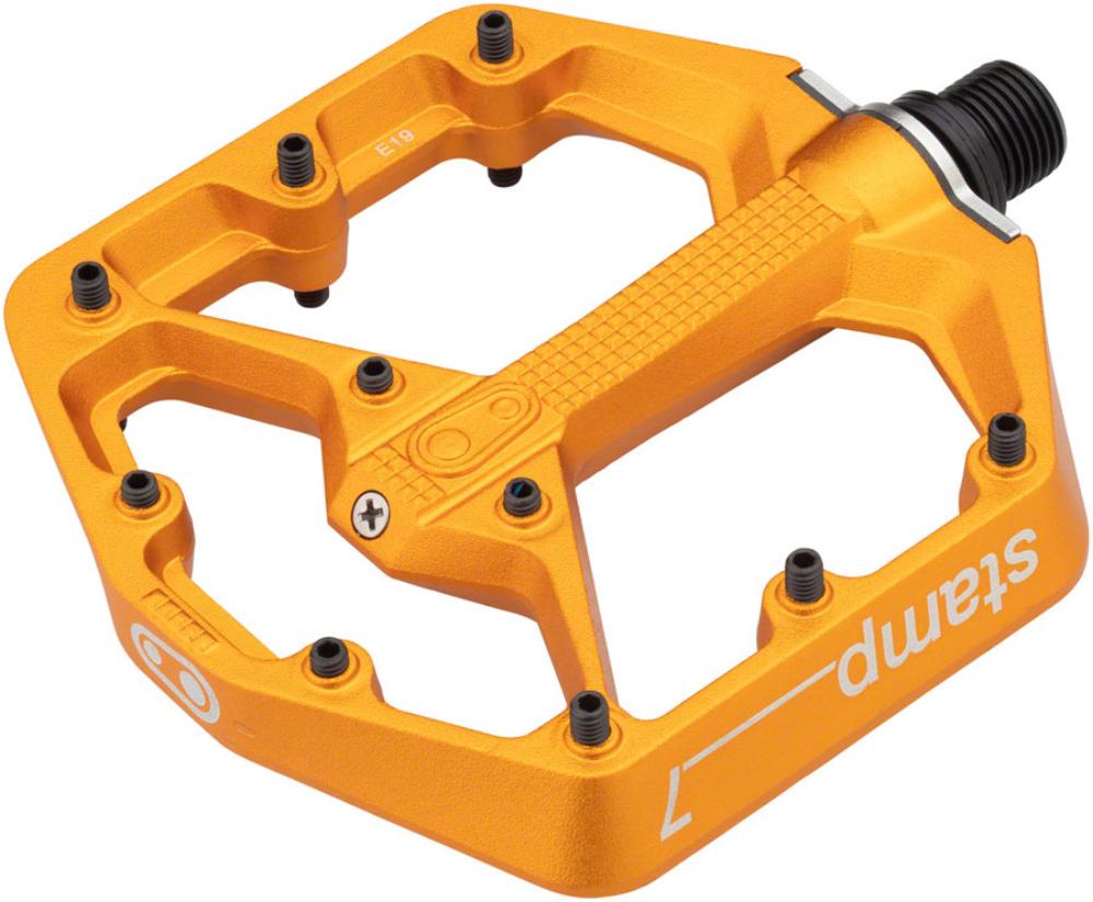 Bright orange aluminum flat pedal with a hexagonal shape, featuring multiple grip pins for traction and a durable construction, designed for cycling.