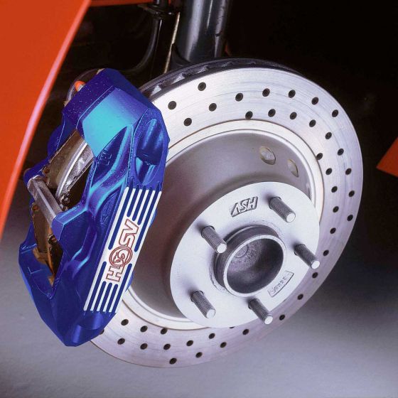 Blue and black brake caliper mounted on a silver disc, featuring drilled holes, with visible brake pads and a detailed logo on the caliper.