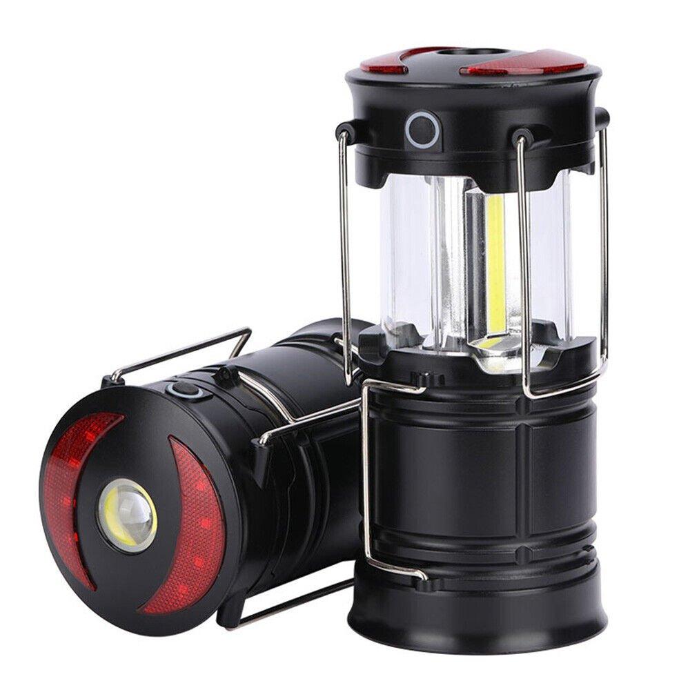 Black LED portable camping torch with a transparent lantern body, featuring a USB rechargeable design, red accents, and a sturdy metal handle for easy carrying.