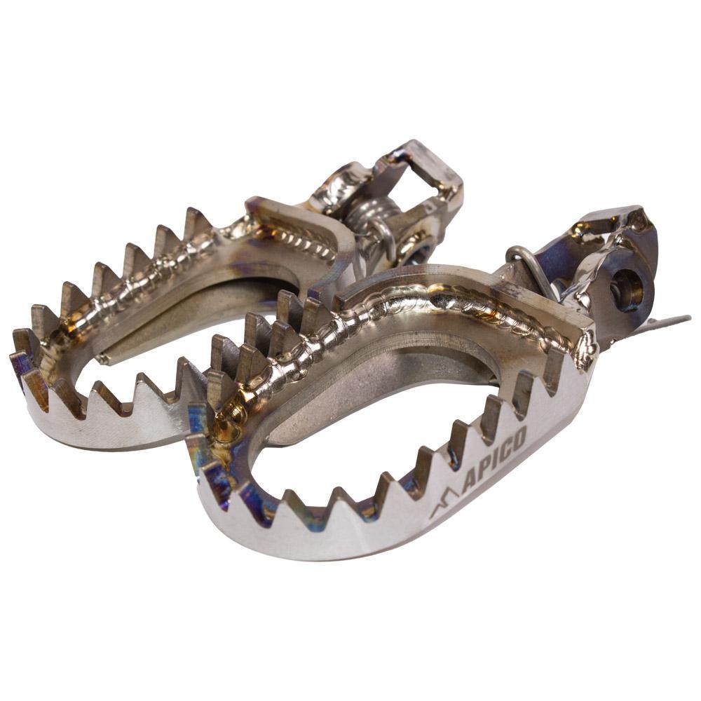 Open design titanium foot pegs with a shiny metallic finish, featuring serrated edges for grip, designed for KTM SX85, SX125/250, and SXF models from 2016 to 2023.