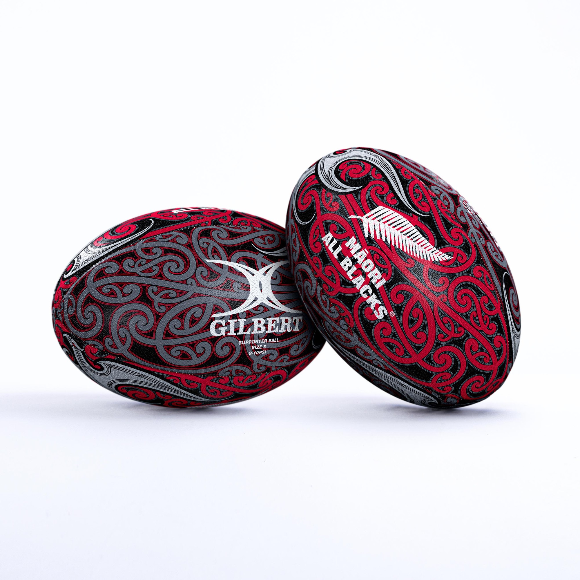 Gilbert All Blacks Māori Supporter Ball featuring a black and red design with intricate Māori patterns, made of durable rubber, showcasing the Gilbert logo prominently.