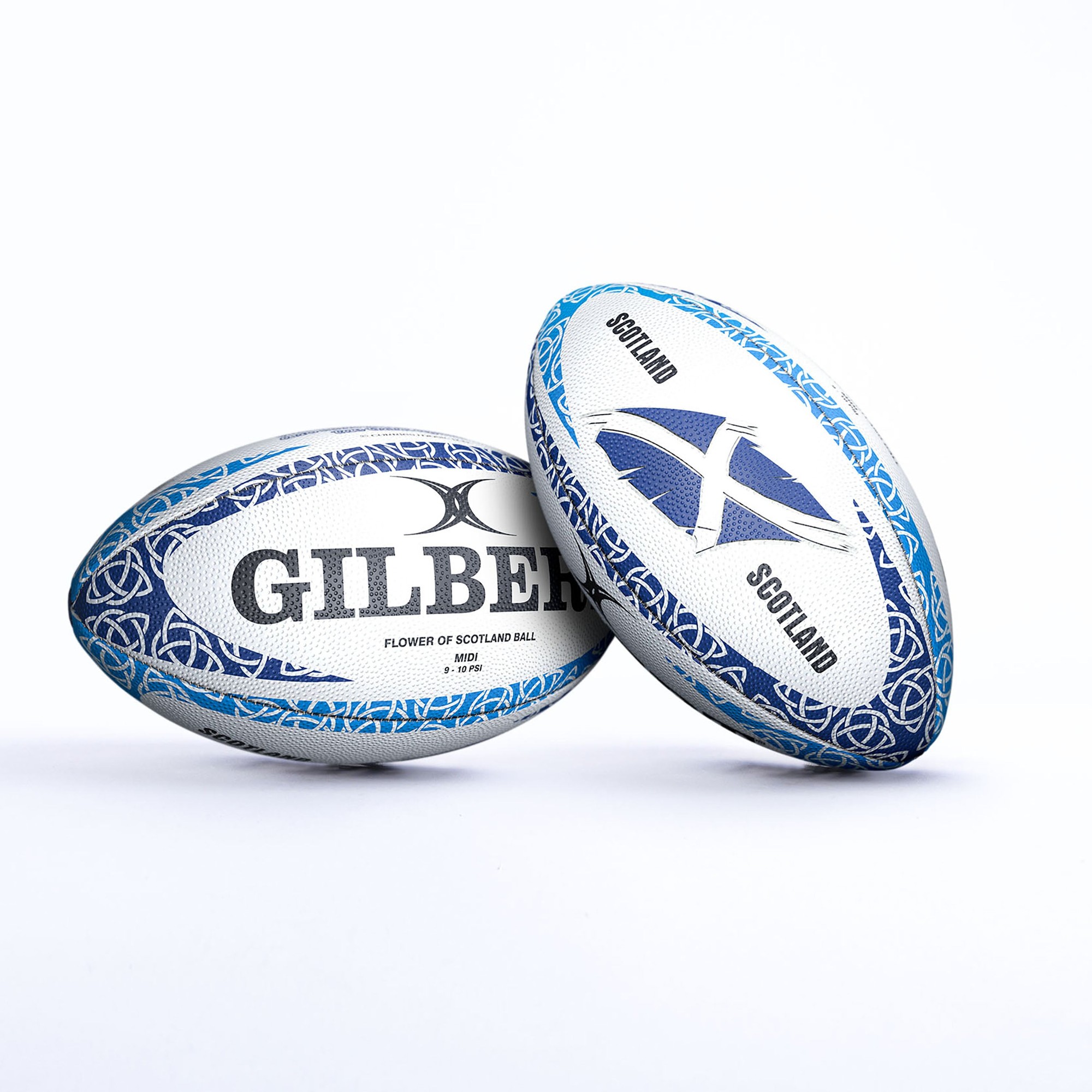 White rugby ball with blue and black designs, featuring "GILBERT" text and "FLOWER OF SCOTLAND" label, adorned with a Scottish flag and intricate patterns.
