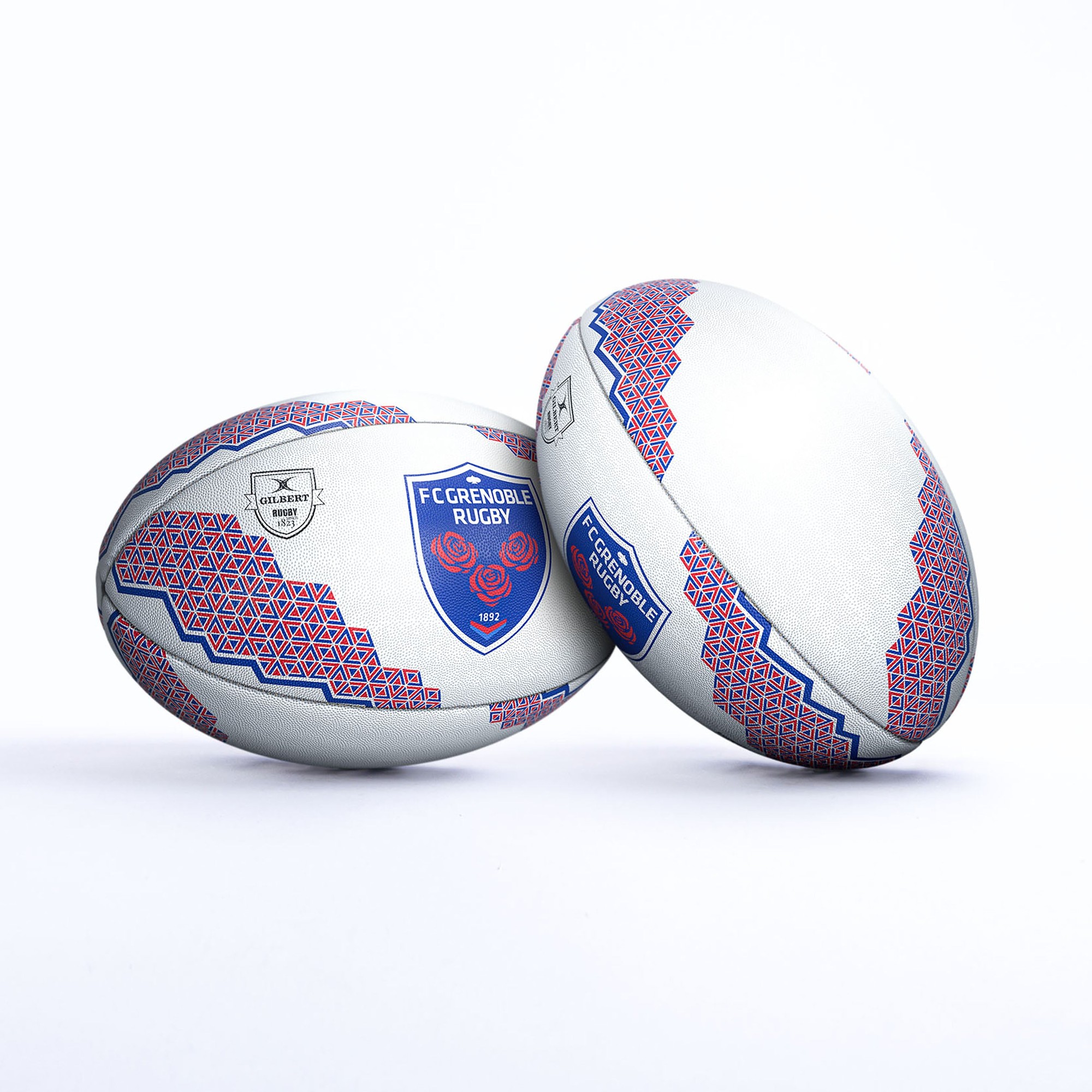 White rugby ball featuring blue and red geometric patterns, with the FC Grenoble Rugby logo prominently displayed on one side.