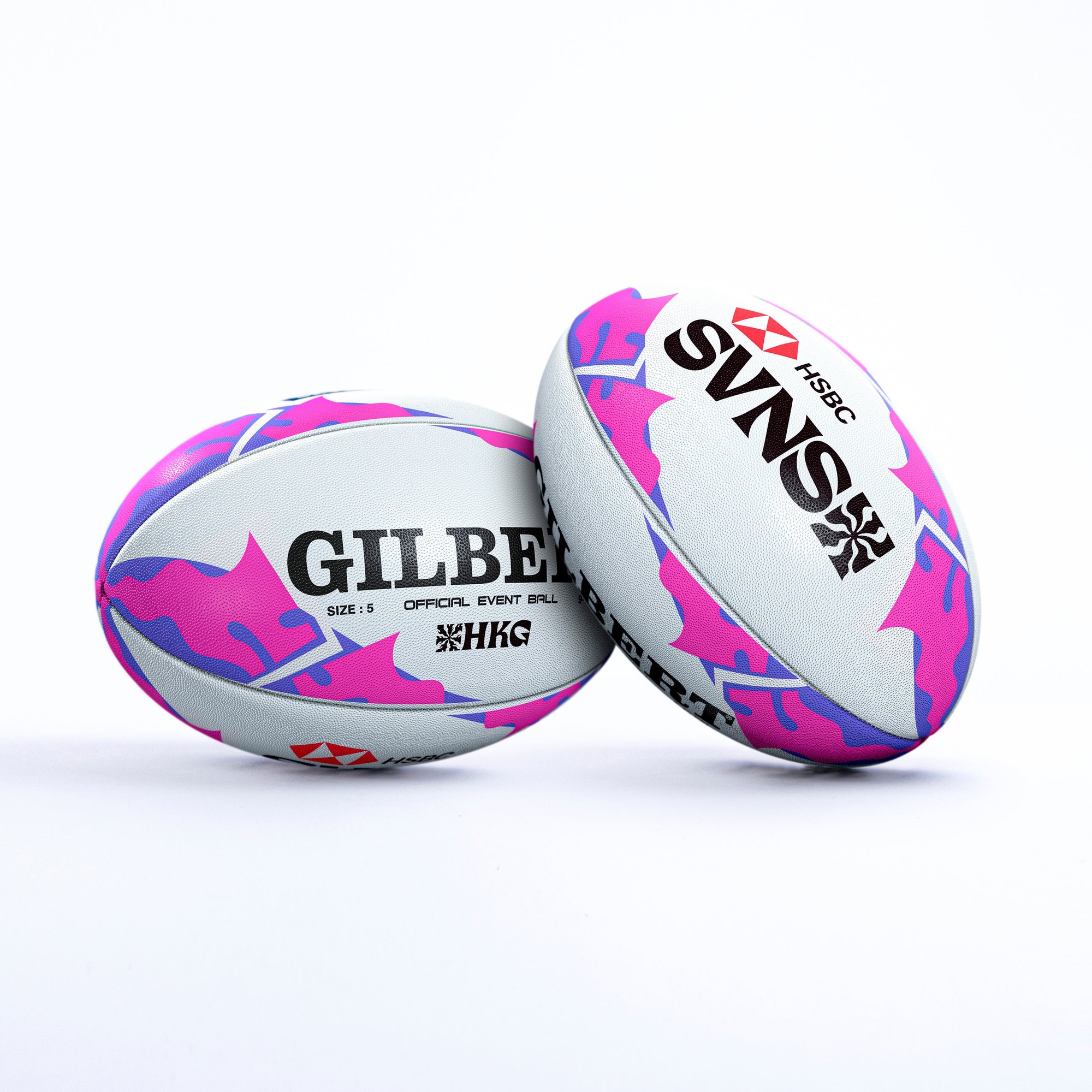 Two Gilbert rugby balls featuring a grey base with vibrant pink and purple camouflage patterns, labeled "GILBERT" and "SVNS" with HSBC logo, designed for event use.